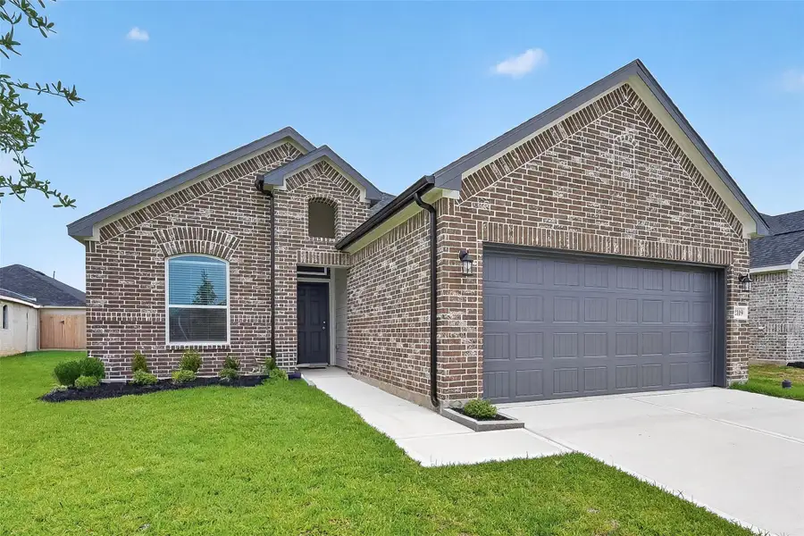 Front exterior of a new home in Grand Magnolia, Magnolia, TX, highlighting curb appeal (Image 2). Front exterior of a new home in Grand Magnolia, Magnolia, TX, highlighting curb appeal (Image 2).