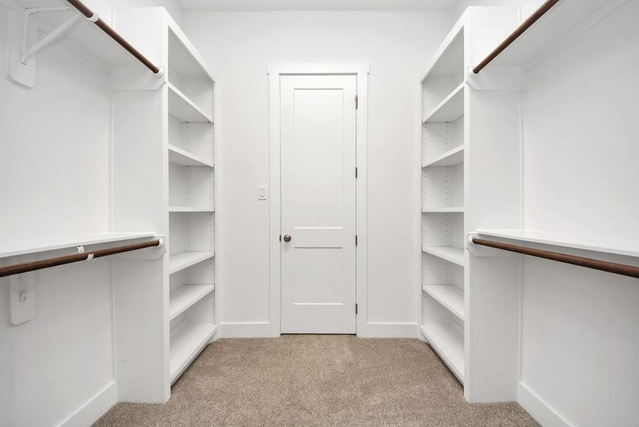 Generous primary closet with plenty of hanging and storage space.