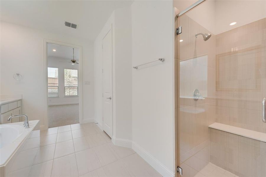 Bathroom featuring plus walk in shower, ceiling fan, and tile patterned floors