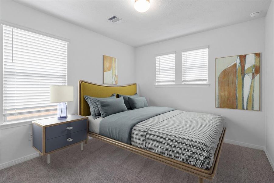 Secondary bedroom features plush carpet, custom paint, lighting, ample closet space, and large windows with privacy blinds.