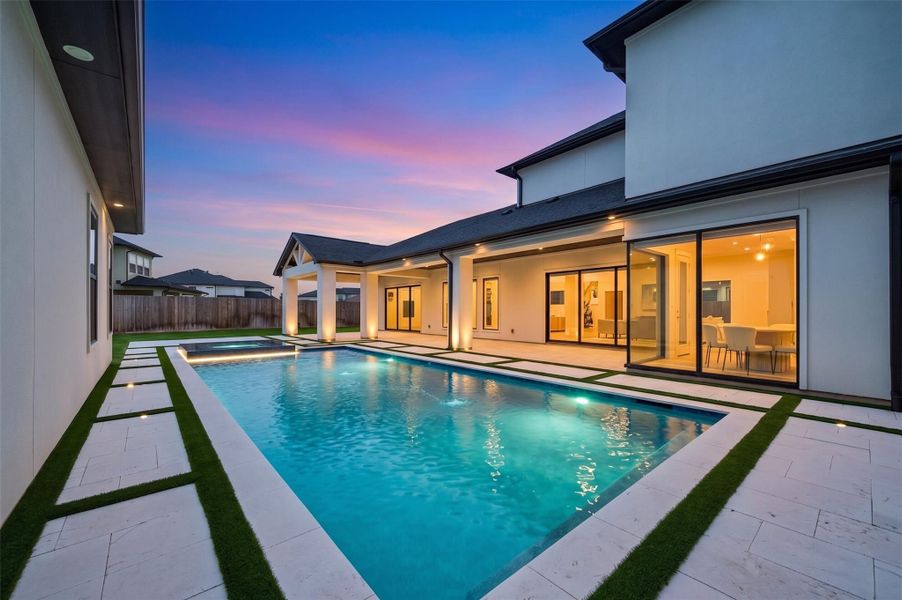 Turf-lined pool surrounds and travertine stepping stones combine style, comfort, and safety.