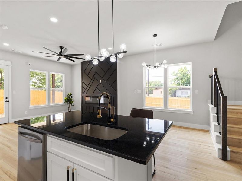 Kitchen island with a dark countertop and undermount sink, complemented by a modern faucet Kitchen island with a dark countertop and undermount sink, complemented by a modern faucet