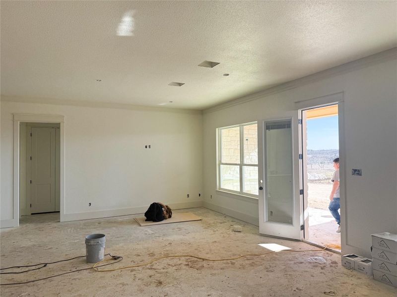 Empty room with a textured ceiling and baseboards