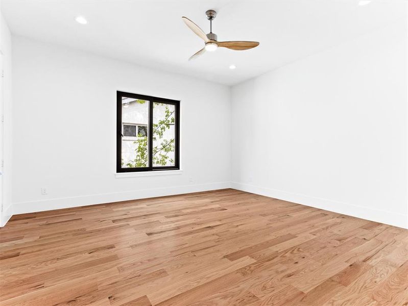 Empty room with ceiling fan and light wood-type flooring