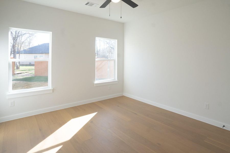 Empty room with wood finished floors and ceiling fan
