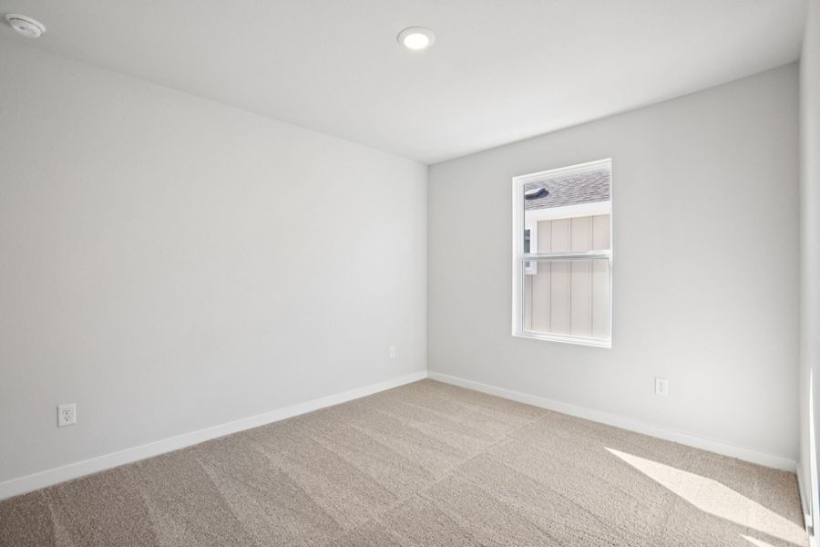 A room with a window and carpet.