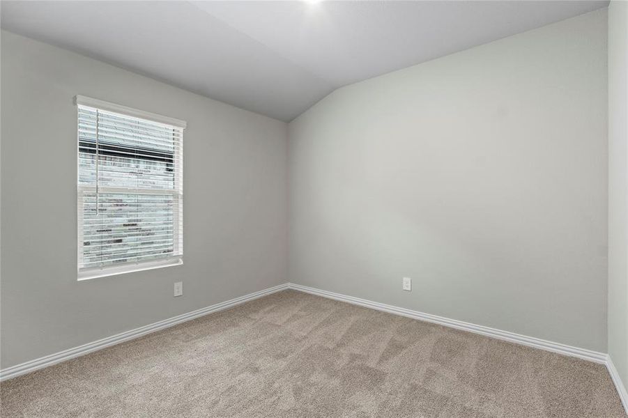 Spare room featuring carpet floors and vaulted ceiling Spare room featuring carpet floors and vaulted ceiling