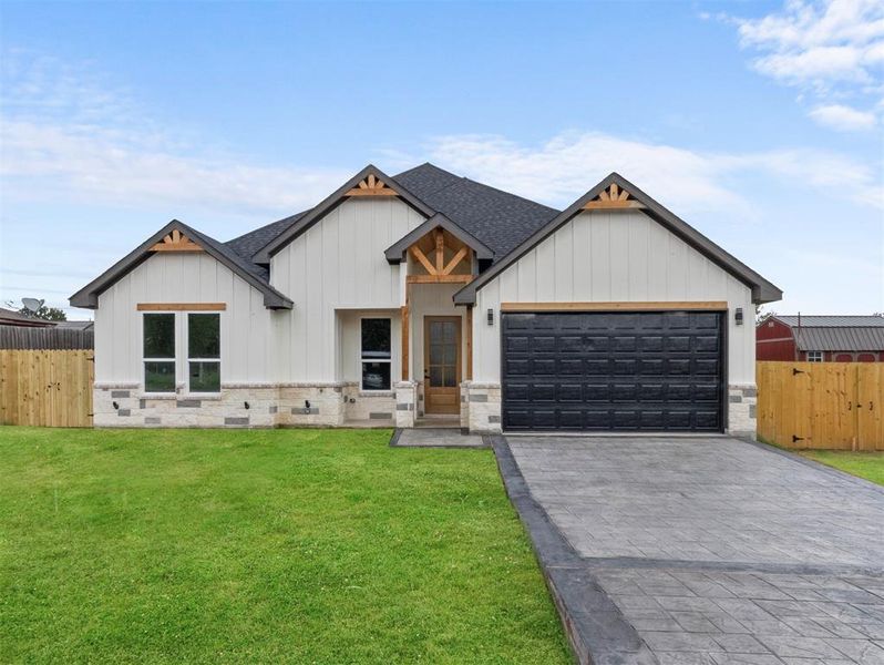 Modern farmhouse style home with a front yard and a garage