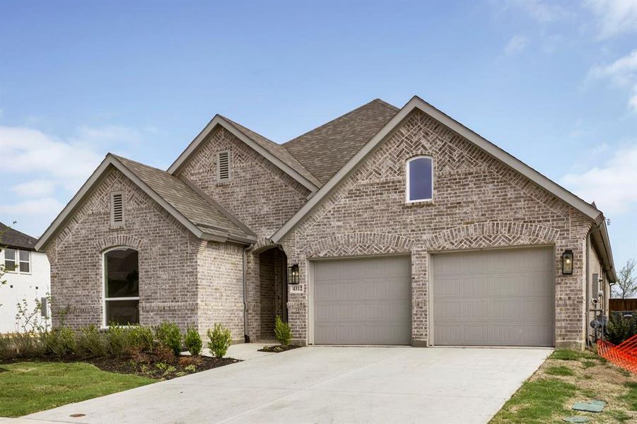 French country style house featuring brick siding, driveway, a shingled roof, and an attached garage