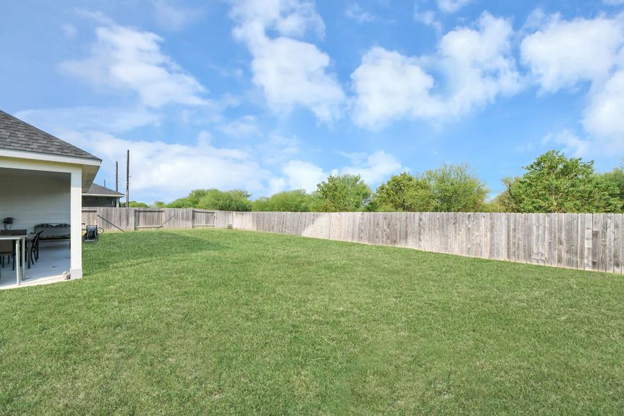 A fully fenced green expanse providing a private canvas for pets, play, or custom outdoor additions.