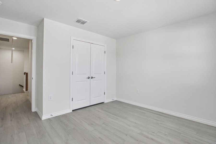 Unfurnished bedroom featuring light wood finished floors, a closet, and recessed lighting