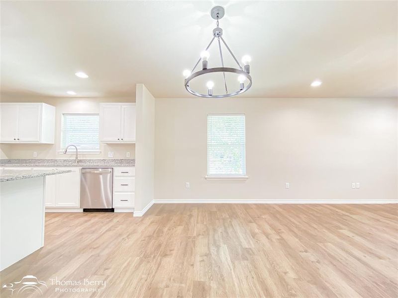 Kitchen featuring white cabinetry, recessed lighting, light wood finished floors, stainless steel dishwasher, and pendant lighting Kitchen featuring white cabinetry, recessed lighting, light wood finished floors, stainless steel dishwasher, and pendant lighting