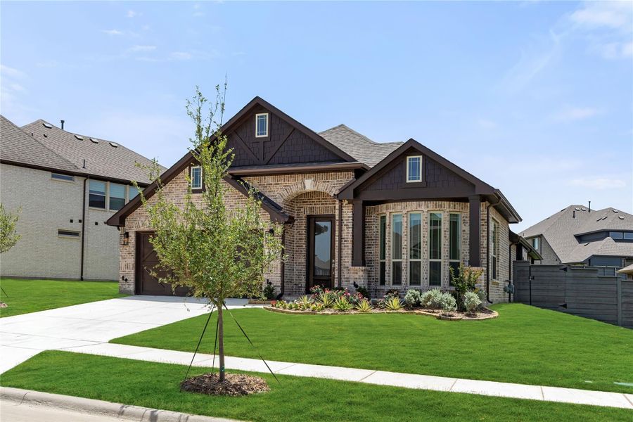 Single-story brick home with dark wood trim, arched entry, one-car garage, and landscaped front yard Single-story brick home with dark wood trim, arched entry, one-car garage, and landscaped front yard