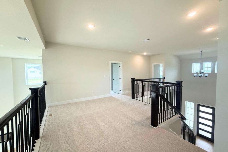 A spacious landing area above the main living space with a sweeping staircase. A spacious landing area above the main living space with a sweeping staircase.