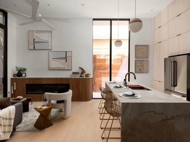 Clean architectural lines define this open space with a waterfall island and sleek linear fireplace.