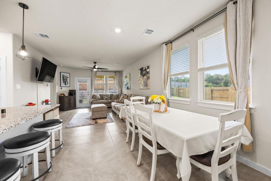 The bright open-concept living and dining area is filled with natural light from oversized windows, creating a warm and inviting atmosphere to enjoy!