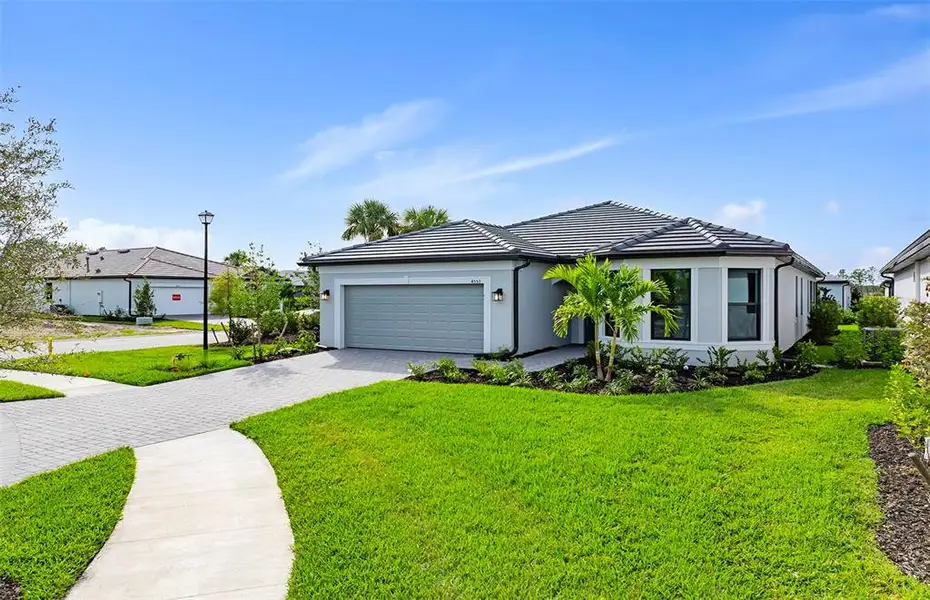 Front exterior of a new home in , North Port, FL, highlighting curb appeal (Image 1). Front exterior of a new home in , North Port, FL, highlighting curb appeal (Image 1).