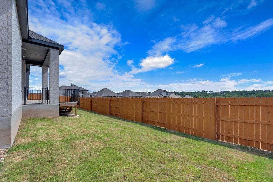 Fenced backyard with a residential view Fenced backyard with a residential view