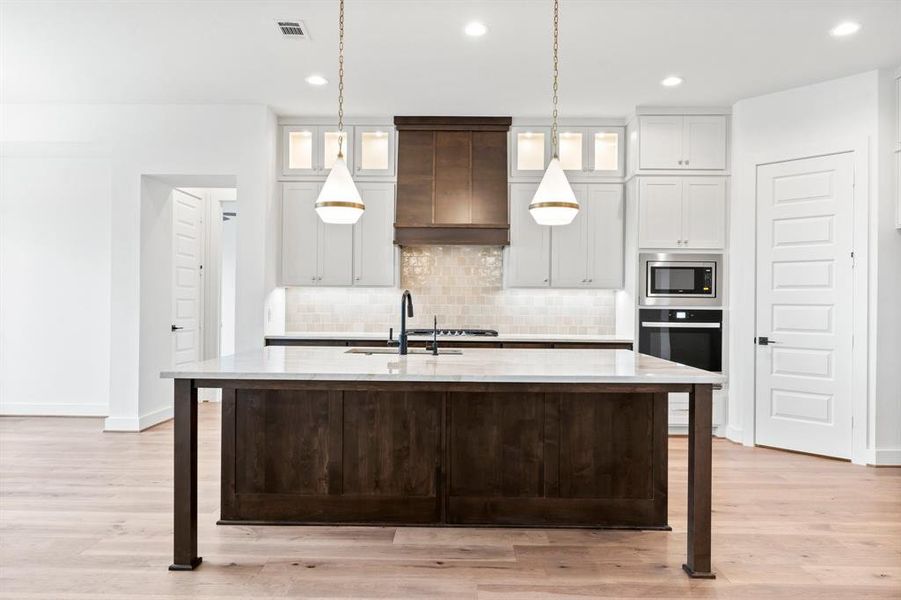 Gorgeous Kitchen with Cabinets to the Ceiling, Wood Vent Hood, and Cabinet Hardware.