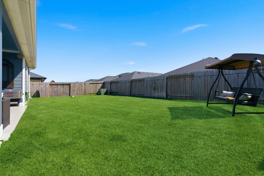 Fully fenced backyard with a covered patio—ideal for outdoor dining or weekend lounging. Fully fenced backyard with a covered patio—ideal for outdoor dining or weekend lounging.