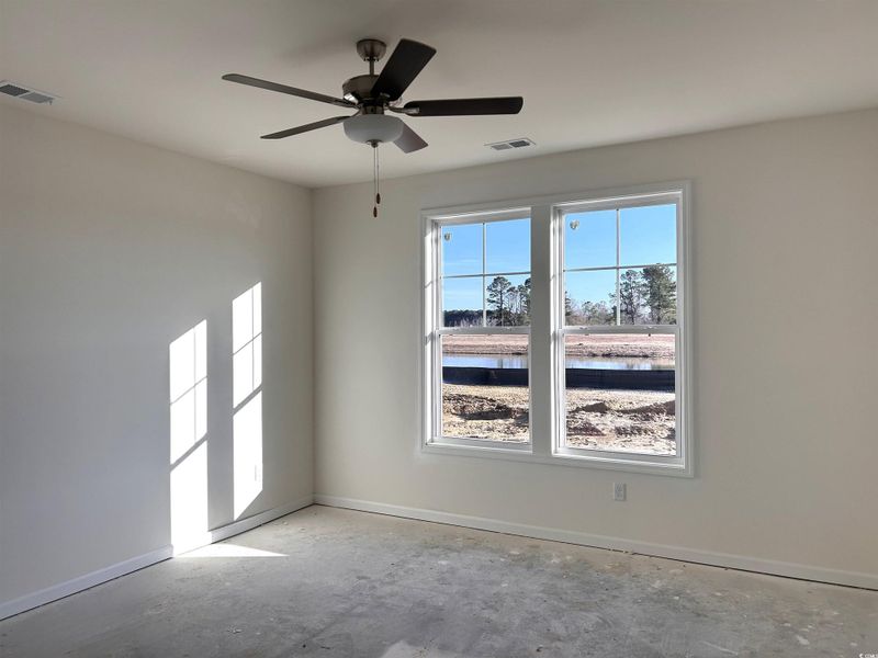 Spare room featuring a water view, concrete flooring, and ceiling fan