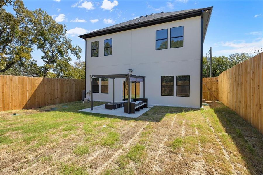 Rear view of house featuring an outdoor living space, a pergola, a patio area, and a lawn