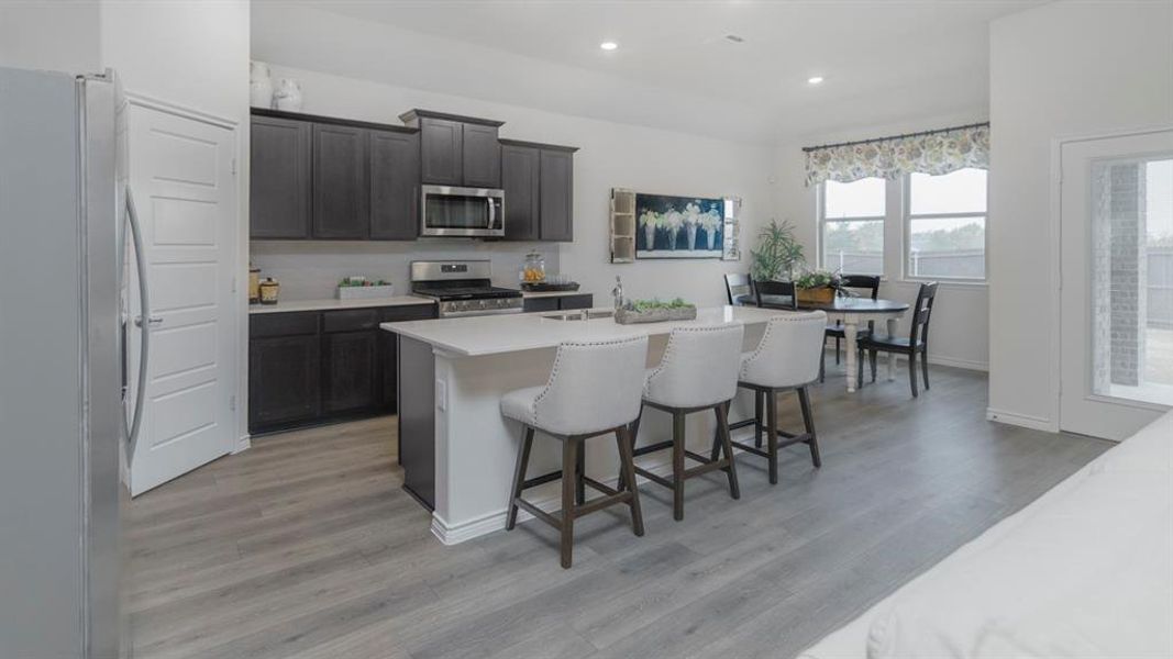 Open-concept kitchen and dining area featuring light wood-finish flooring