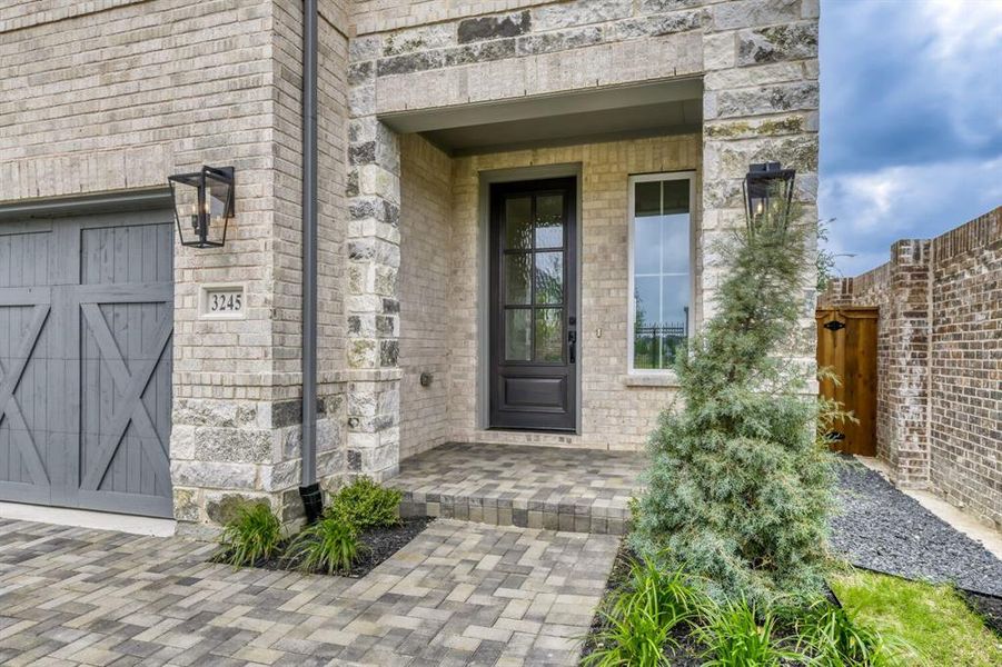 Exterior showcasing light-toned brick and stacked stone accents
