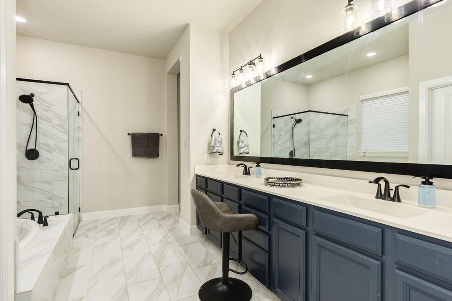 The primary bath has double vanities, a soaking garden tub, a glass walk-in shower, and private water closet