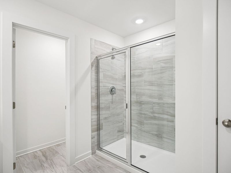 The primary bathroom offers dual vanity sinks and a walk-in shower.