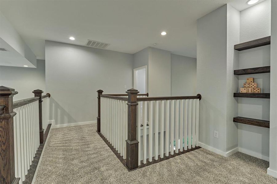 Built in shelves provide a display area for games, photos, or other items of interest. The balcony area overlooks the living room and the entry foyer.