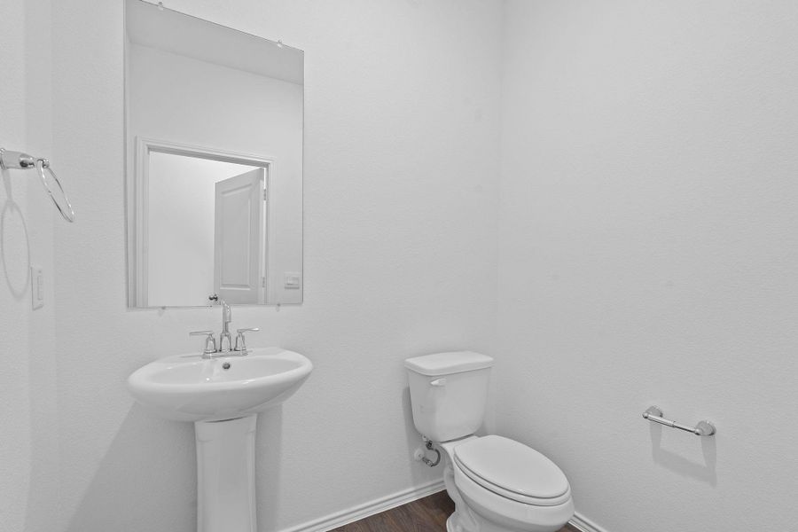 Half bath featuring baseboards and dark wood-type flooring Half bath featuring baseboards and dark wood-type flooring
