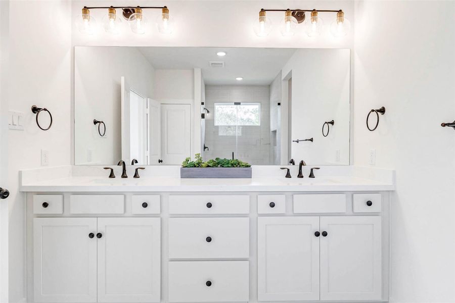 Beautiful double-door entry with magnetic soft-close.Dual sinks with tall counters, soft-close cabinetry, brushed bronze hardware and gold accented lighting.