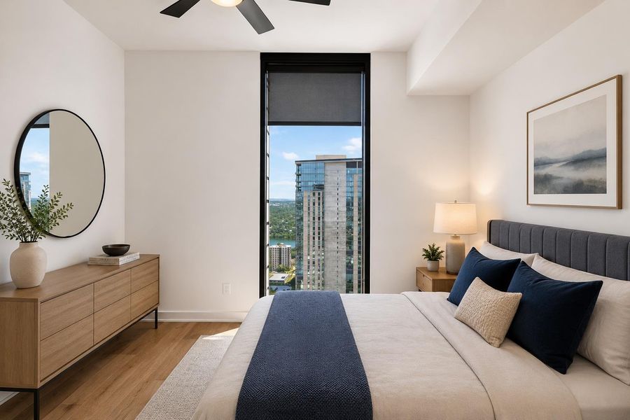City views and natural light illuminate this well-appointed bedroom, offering comfort and style.
