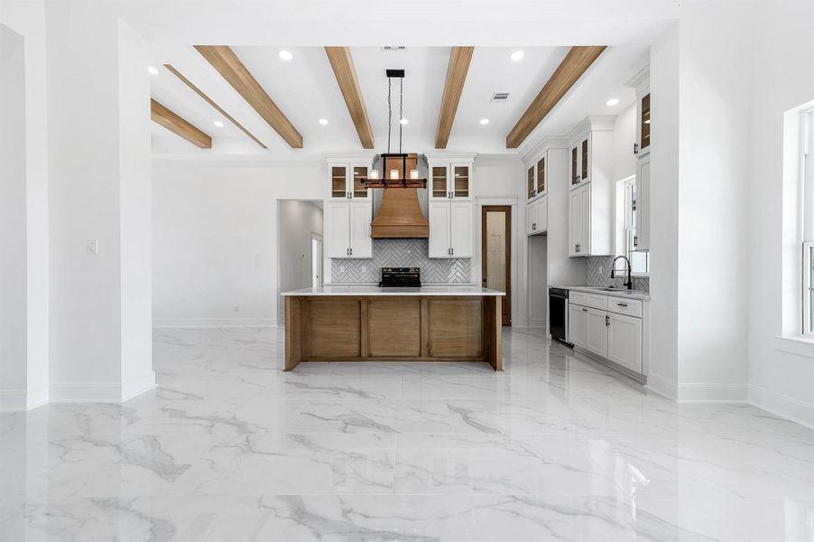 Open-concept living and kitchen area featuring beautiful wood accents, custom cabinetry, and a spacious layout. Open-concept living and kitchen area featuring beautiful wood accents, custom cabinetry, and a spacious layout.