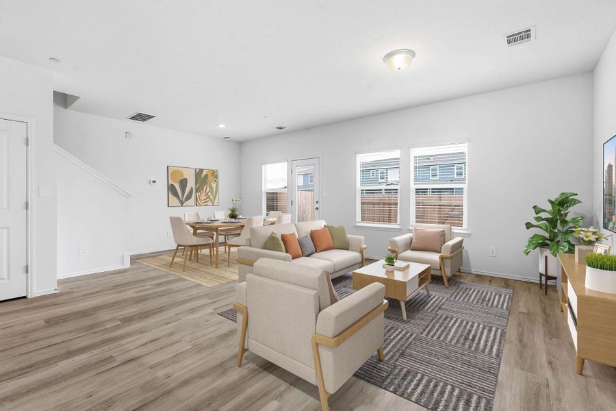 Open-concept living area with wood-finish flooring, recessed lighting, and multiple windows Open-concept living area with wood-finish flooring, recessed lighting, and multiple windows