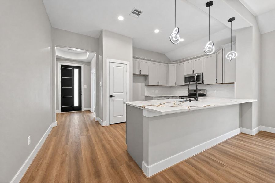 Thoughtfully designed kitchen featuring a large island, ample cabinetry, and an open flow to the main living areas.