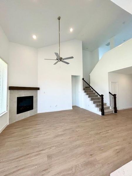 Spacious room featuring high vaulted ceilings, recessed lighting, and wood-finish flooring