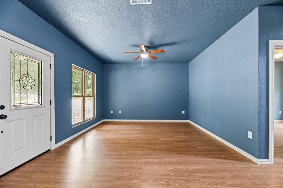 Foyer entrance with ceiling fan, light hardwood / wood-style floors, and a textured ceiling Foyer entrance with ceiling fan, light hardwood / wood-style floors, and a textured ceiling