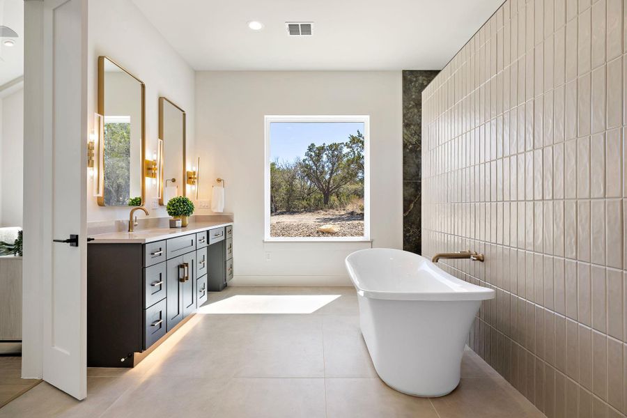 Full bathroom with visible vents, vanity, a freestanding bath, tile walls, and tile patterned floors