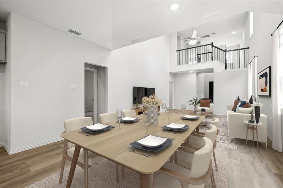 Dining room featuring a towering ceiling, light wood-style flooring, a ceiling fan, baseboards, and recessed lighting Dining room featuring a towering ceiling, light wood-style flooring, a ceiling fan, baseboards, and recessed lighting