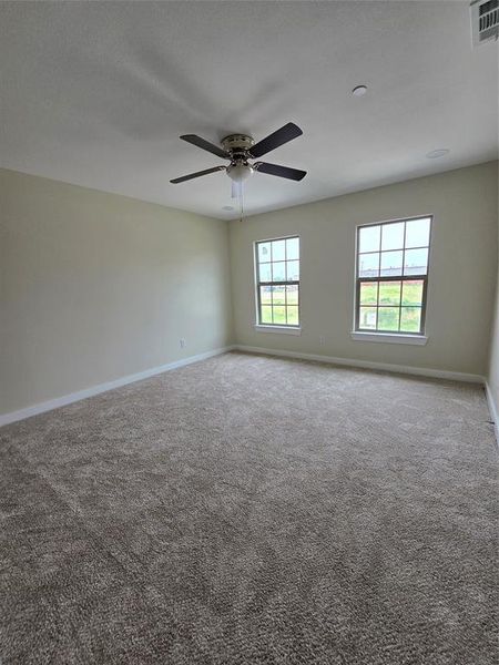 Carpeted spare room with baseboards and ceiling fan