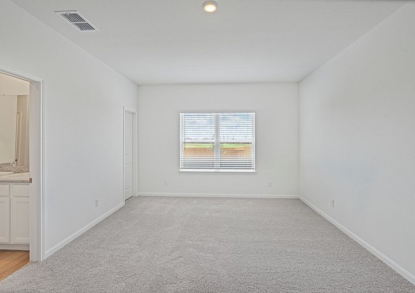 Spcaious master bedroom with a large window