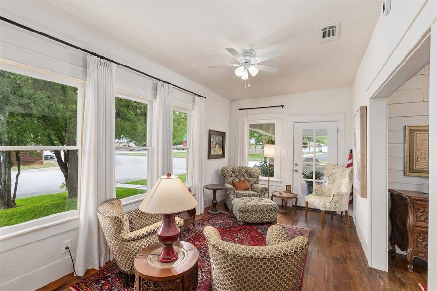 Living space featuring multiple windows, a ceiling fan, and wood-finish flooring