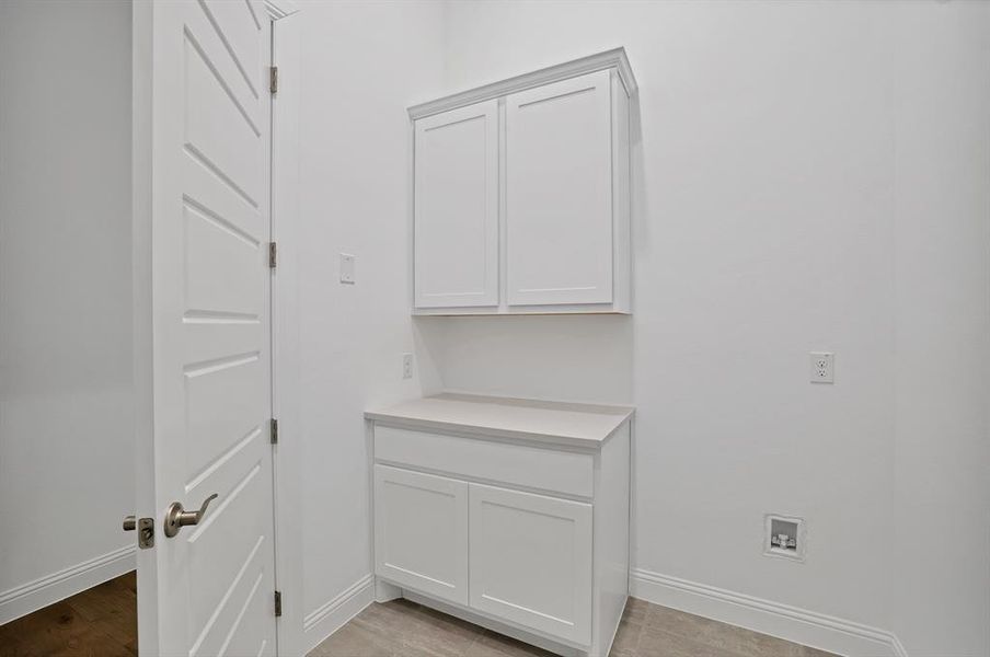 Laundry room featuring cabinets and tile flooring