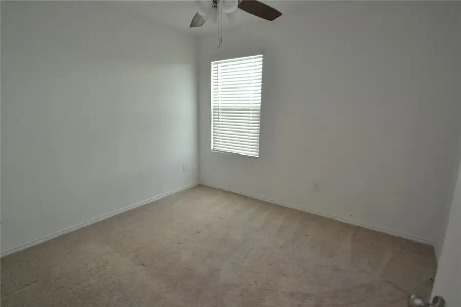Spare room with light colored carpet and a ceiling fan