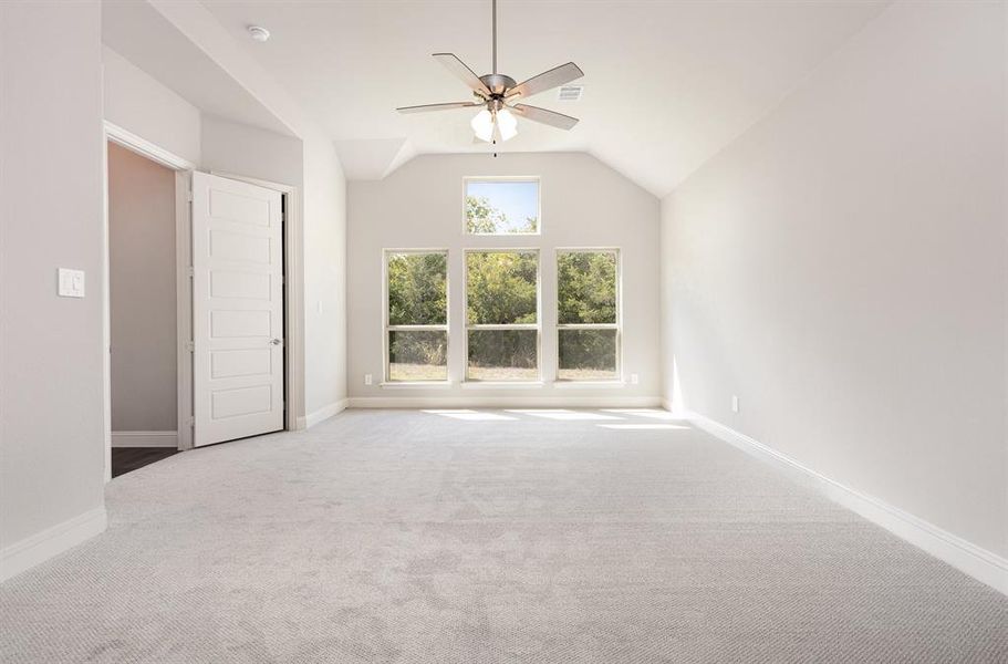 Spare room featuring light carpet, a ceiling fan, and lofted ceiling Spare room featuring light carpet, a ceiling fan, and lofted ceiling