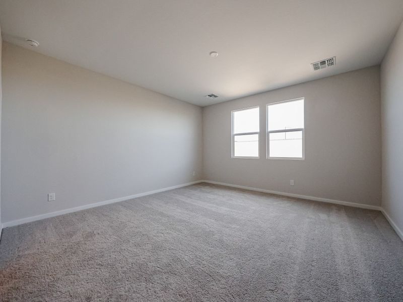 A room with a carpet and windows.