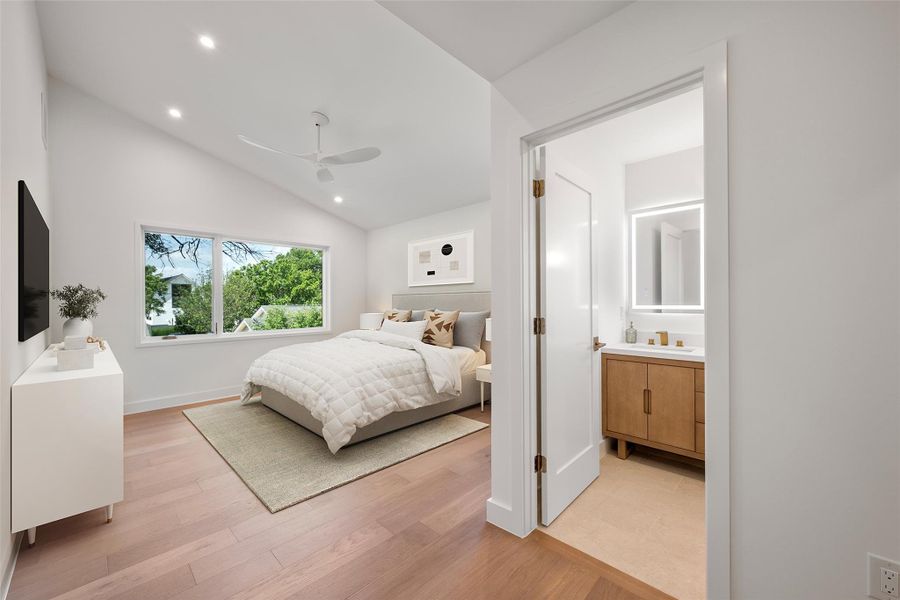 A well-lit primary bedroom features a vaulted ceiling, recessed lighting, and rich hardwood floors. A well-lit primary bedroom features a vaulted ceiling, recessed lighting, and rich hardwood floors.