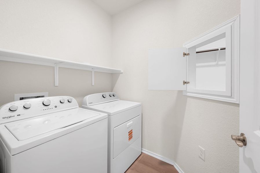 A dedicated laundry room equipped with a convenient shelving unit for storage. A dedicated laundry room equipped with a convenient shelving unit for storage.